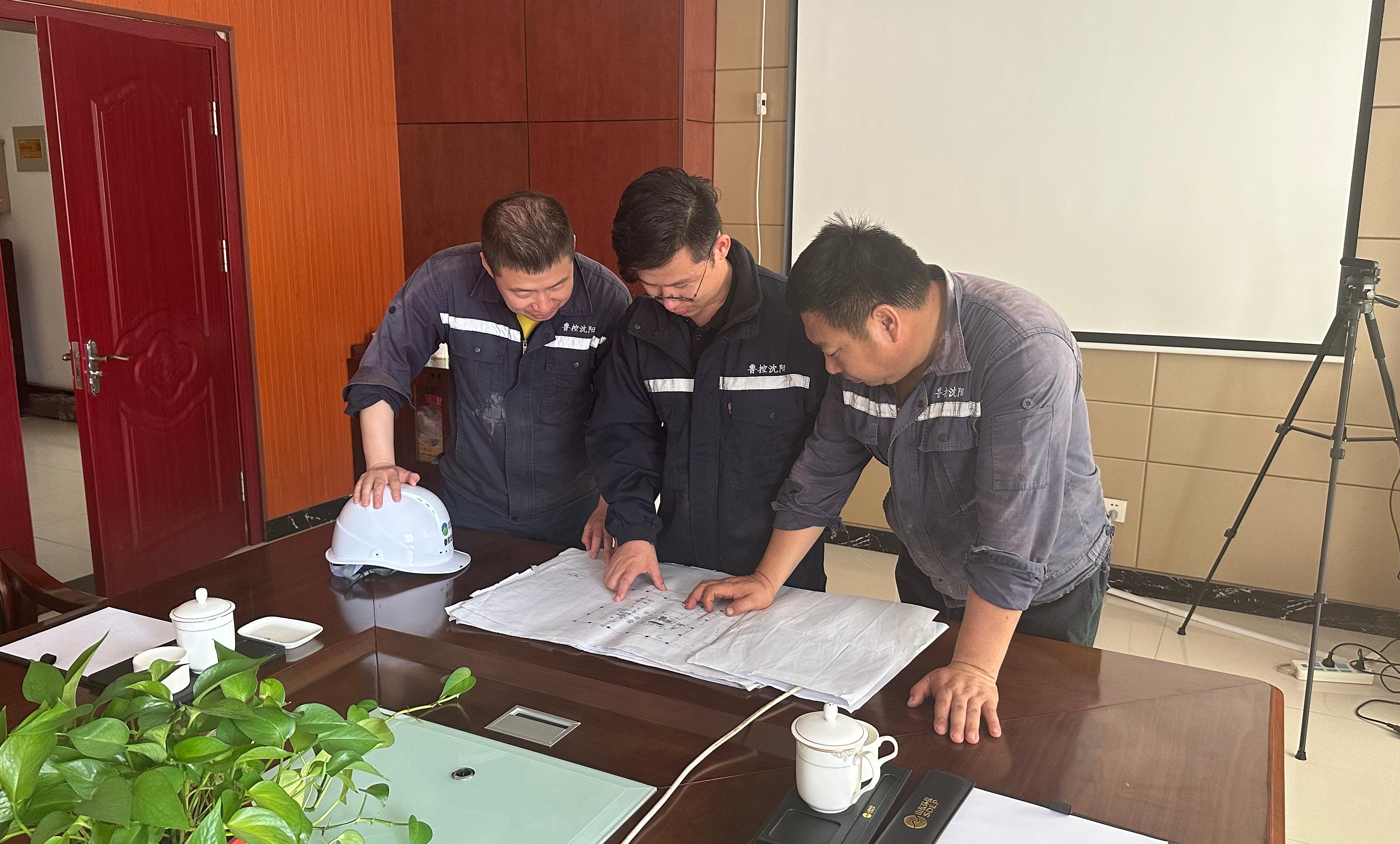 孙茂(中间)与同事研究筛分机调整方案.jpg